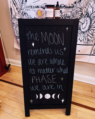 photo of a sign in the Witch Baby store in Cranford that says: the moon reminds us that we are full no matter what phase we're in.