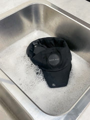 black ballcap soaking in soapy water