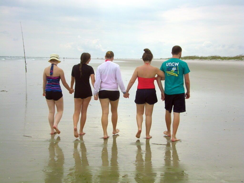 family holding hands on the beach