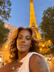 Yamilee Wyatt, owner of Wyatt Hair Collection wearing raw hair extension with the illuminating Eiffel Tower in the background.