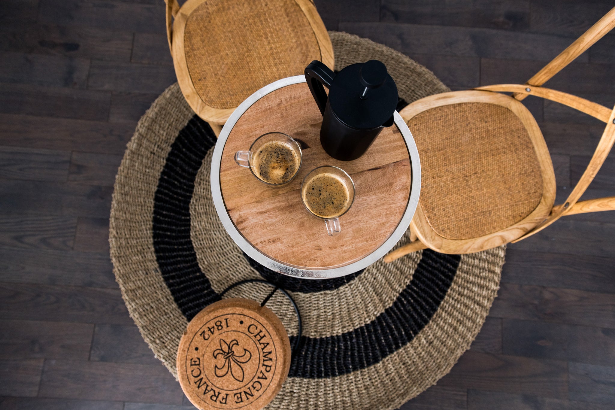 Flat lay view of table and chairs with coffee mugs and flask.