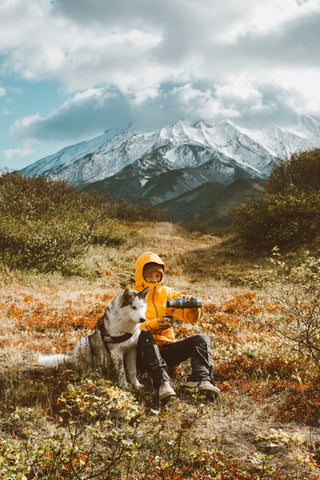 A man and his husky dog hiking and practicing photography