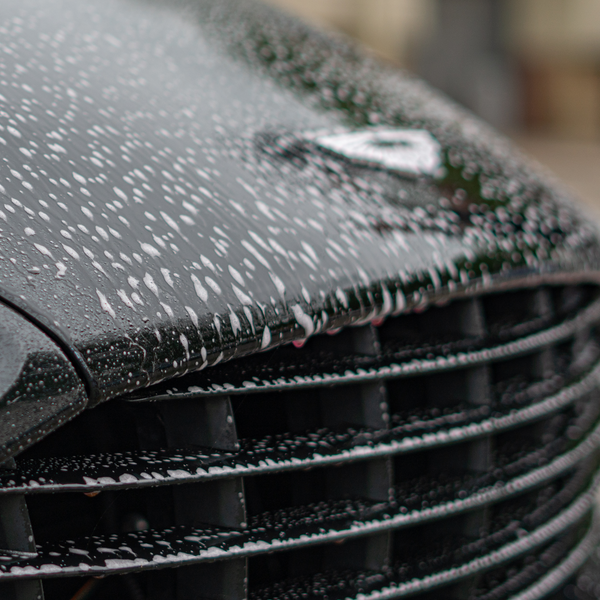 Pre wash freshly sprayed on the front of an aston martin vanquish