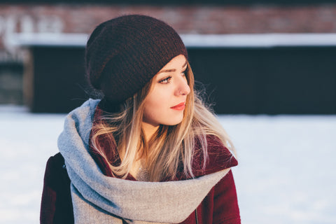 Wear a hat.  It is important to cover your hair during the winter months to shield it from the moisture-robbing dry air, snow, wind, and rain. This is not the time to worry about dreaded hat hair. The elements dry your hair out, making it more prone to breakage.  Wool, cotton, and other fabrics can cause breakage as well, so make sure to line your hat with silk or satin to help prevent damage. Fight static electricity under your hat by using a dry oil spray. Dry oils are weightless and contain natural oils that moisturize hair, bringing back its shine. 