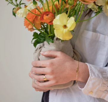 Serpent ring and bracelet on model holding flowers