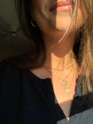 Close up of gold necklaces on model in sunlight