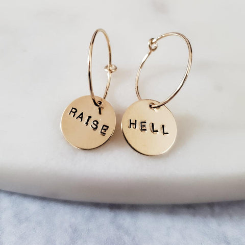 Dainty circle discs on small handmade wire hoops hand-stamped with "RAISE HELL" 