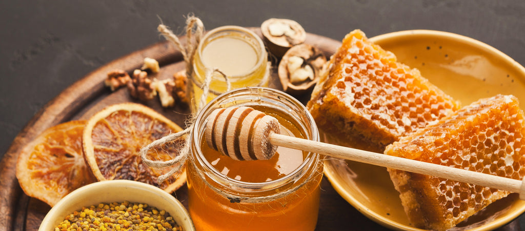 Jar of honey with honeycomb and oatmeal in bowls beside