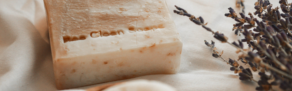honey and oatmeal soap bar with lavender stalks on cotton background