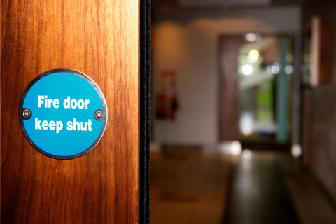 Fire door with blue signposting that says 'Fire door, keep shut'