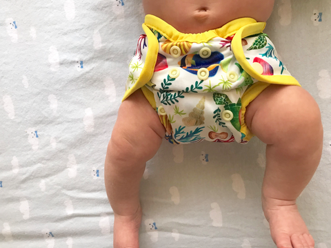 Cómodo Wrap Mini reusable nappy cover on a newborn baby