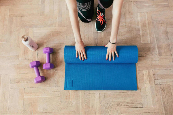 Woman rolling up a yoga mat