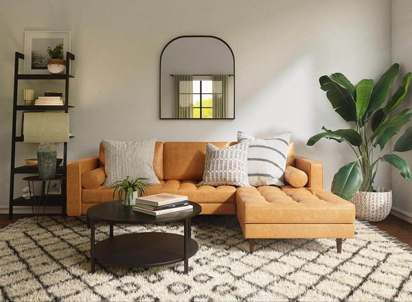 A Cozy Casual Living Room With a Couch, coffee table and a large plant.