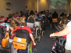 Picture of ISAAC Conference session from Barcelona in 2010 with many AAC users in wheelchairs