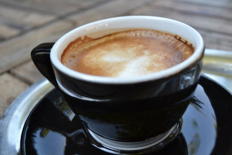 A cup of coffee in a stylish black and white cup and saucer