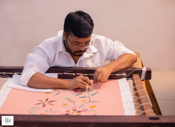 artisan making an embroidered cushion cover for Agasti