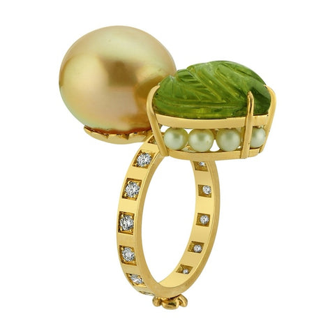 Daphne Toi & Moi ring in 18k yellow gold with a 13 by 13 mm button-shape golden South Sea pearl, a 9.14 ct. carved peridot, 1.47 cts. t.w. akoya pearls, and 0.42 ct. t.w. diamonds by Stella Flame Jewelry