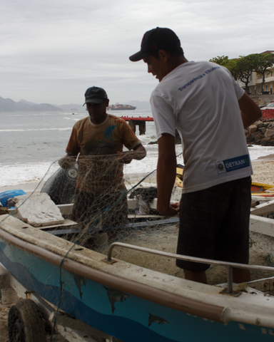 O pescador Manasi e seu pai limpando a rede depois da pesca matinal