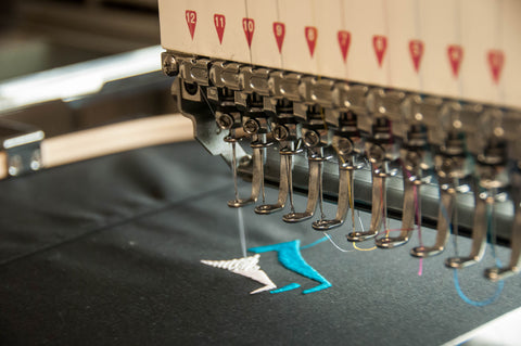 embroidery machine stitching a logo - LMI Textiles