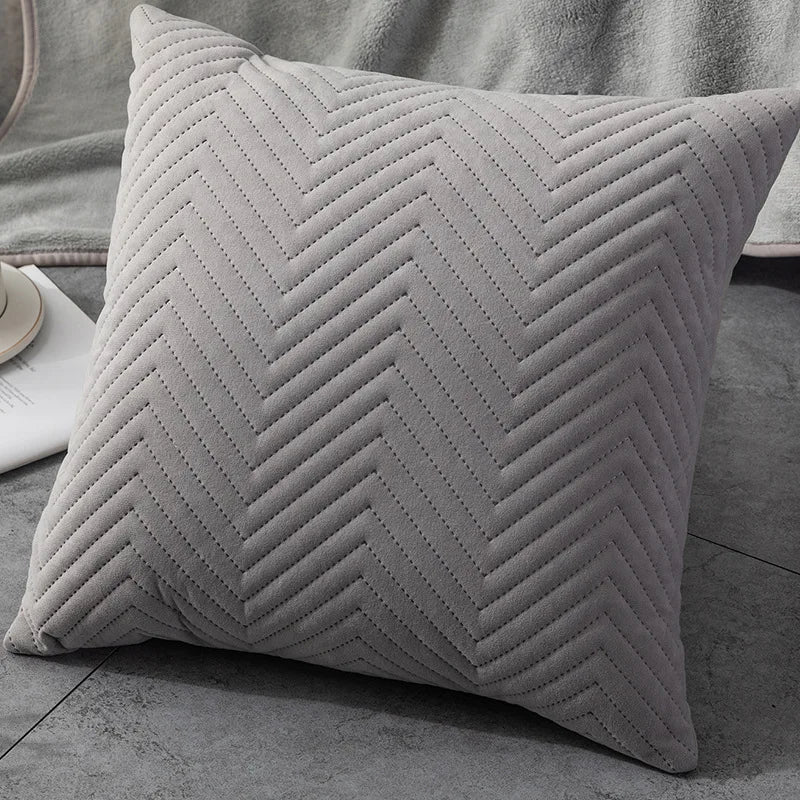 Close-up of a light-grey throw pillow featuring a crisp chevron pattern, showcasing its textured and stylish design 44564829864099