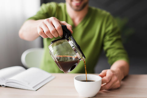 happy man with green shirt pouring coffee