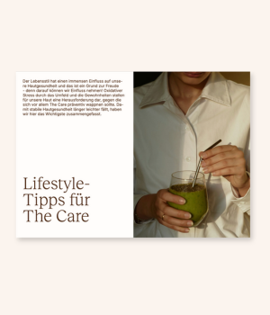 Person in a white shirt holding a drink with a metal straw.