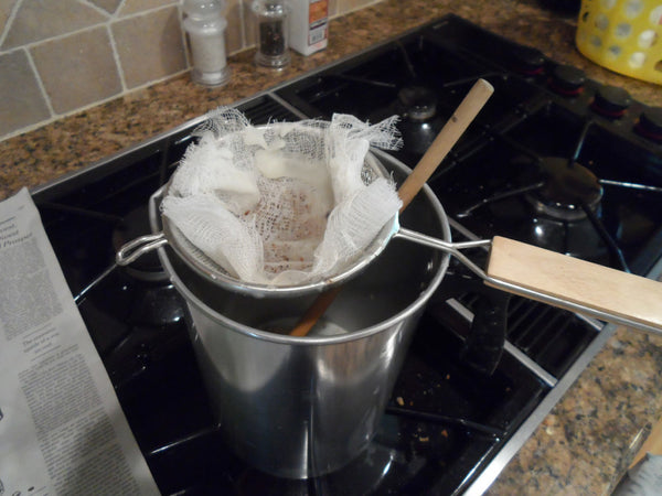 Straining beeswax on the stove.