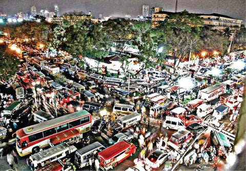 Buses and cars inch their way forward on a gridlocked corner in Manila.