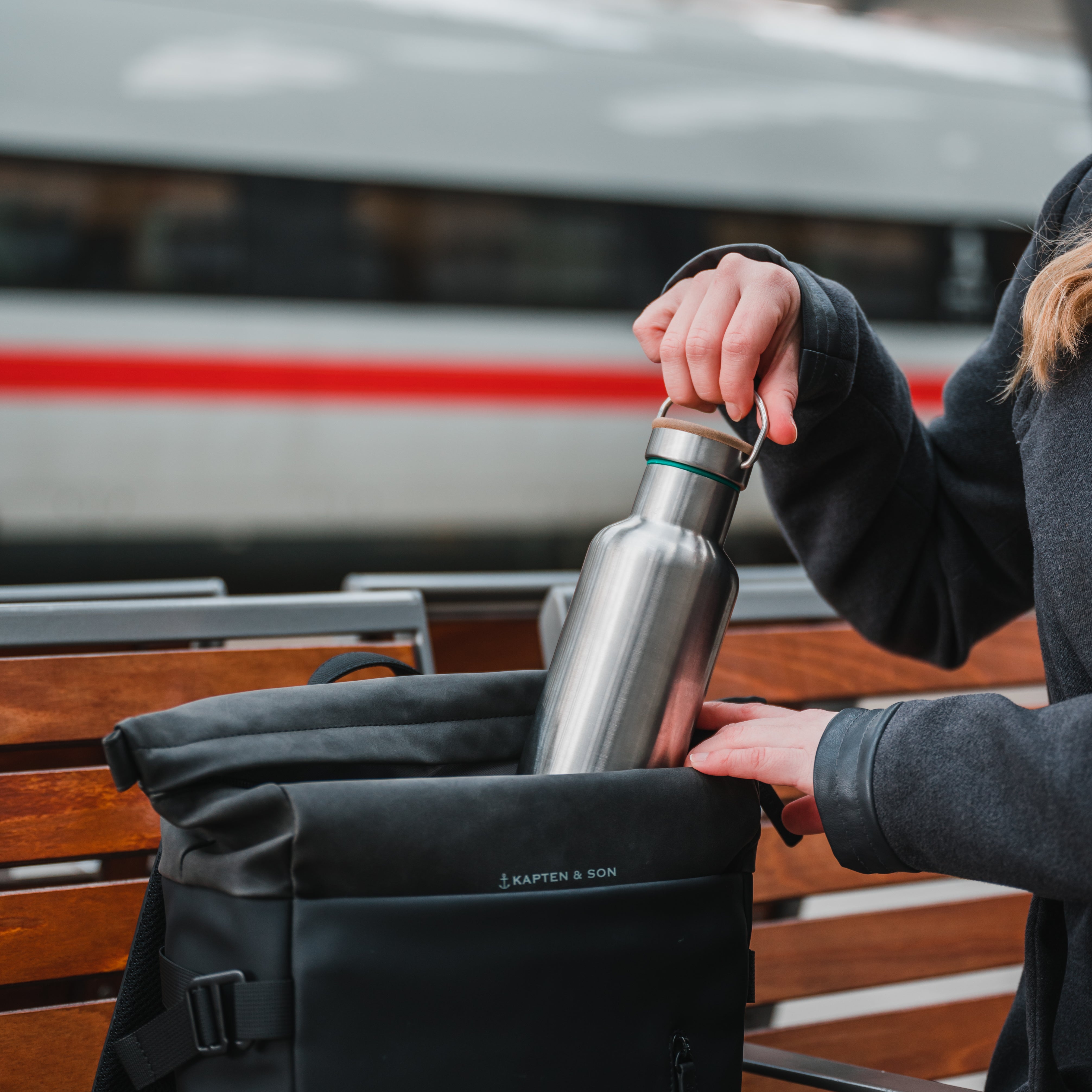 Blockhuette stainless steelwater bottle being packed into a backpack by agirl