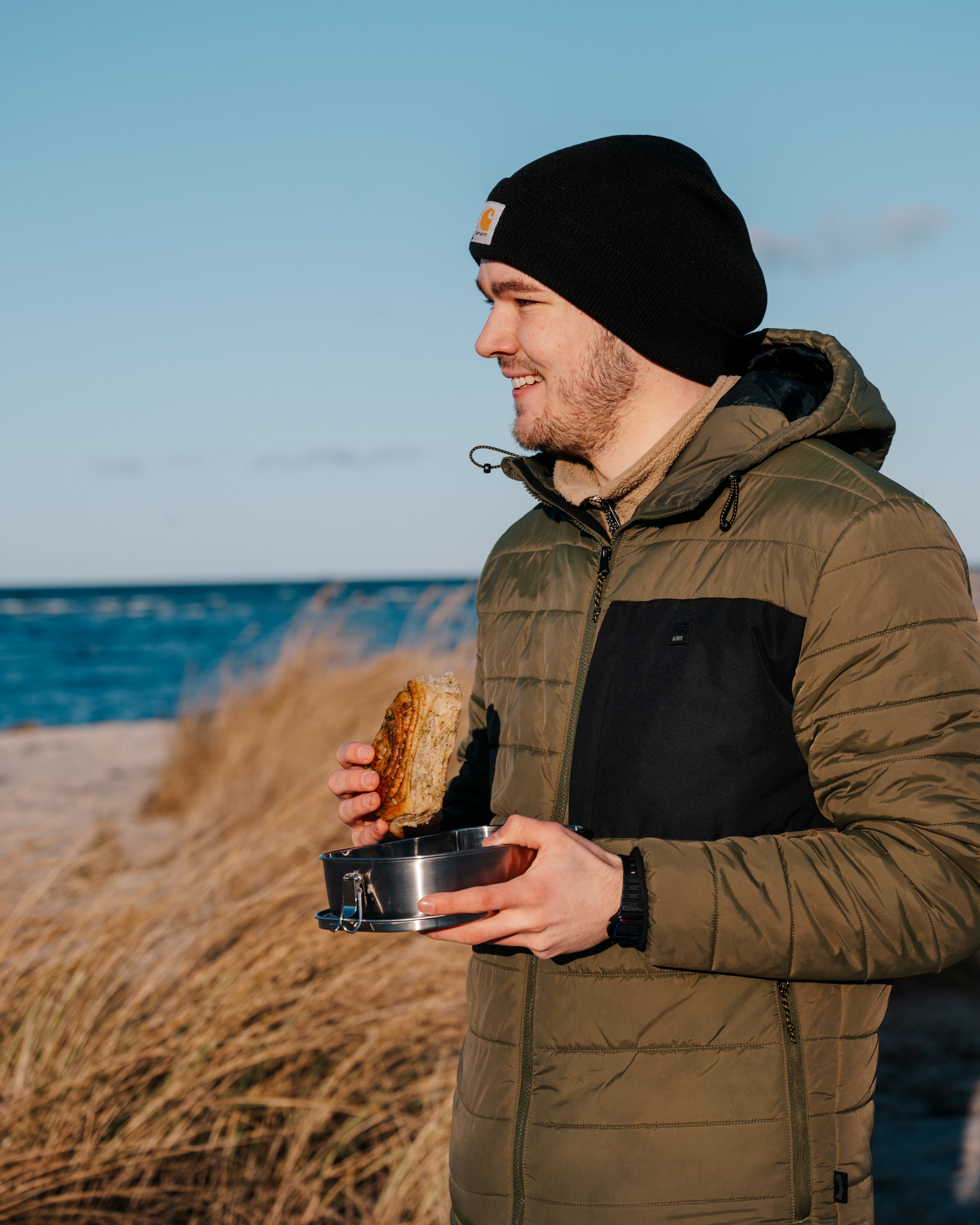 A man eating bread out of Blockhuette stainless steel lunch box