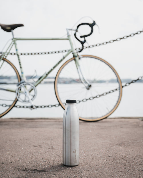 Blockhuette Vacuum Insulated Stainless Steel Water Bottle infront of a bike