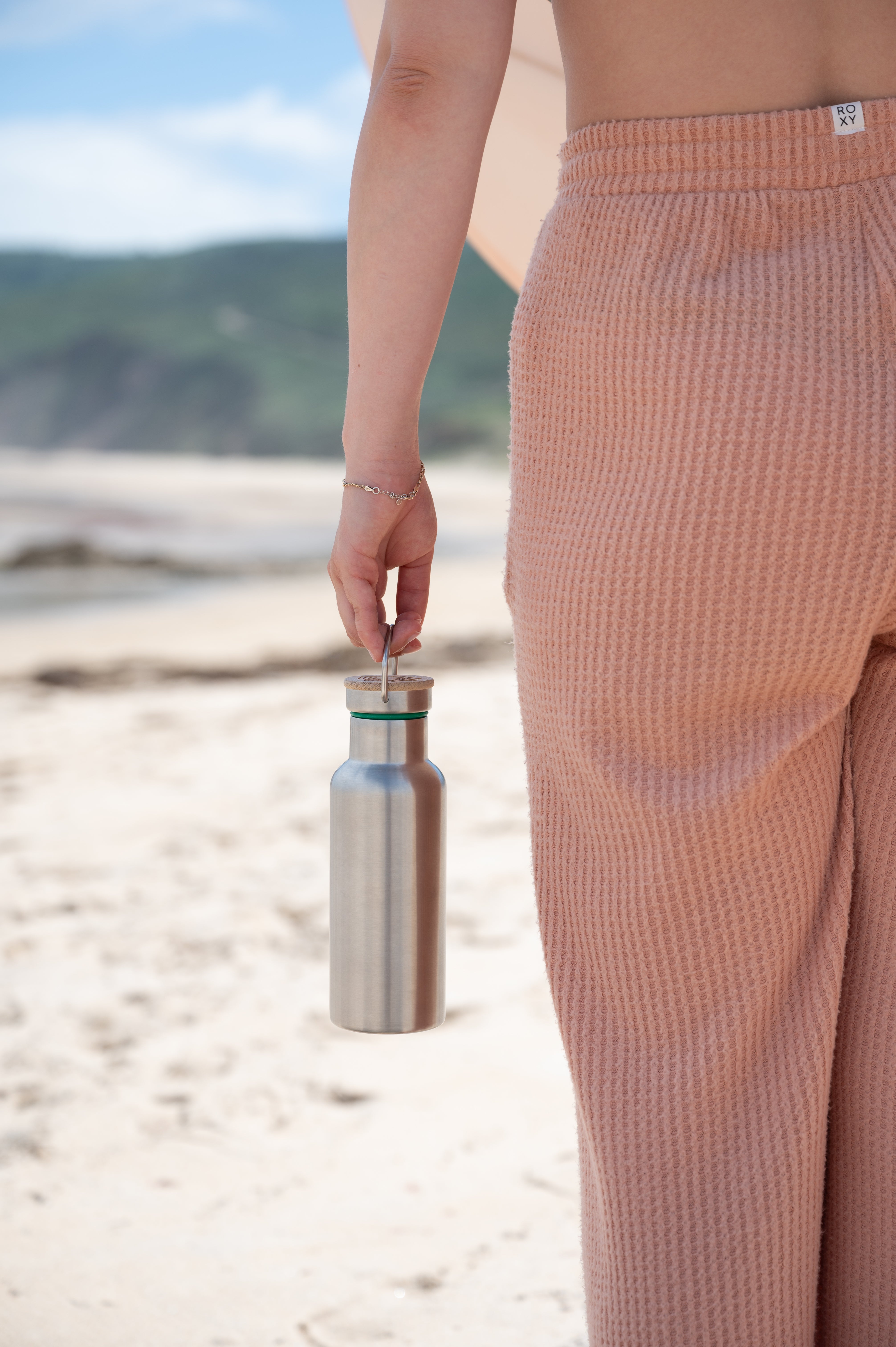 Blockhuette sainless steel water bottle being held by a girl at the beach