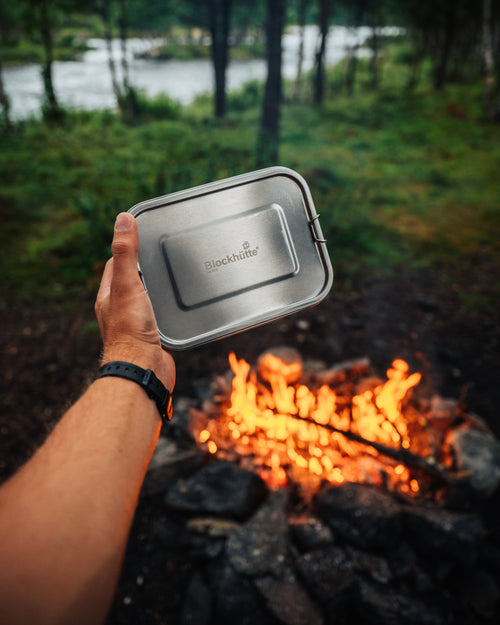 Blockhuette Stainless Steel Lunch Box held in hand infront of a bonfire