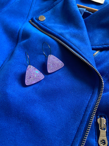 Handmade purple triangular resin earrings, Lila,  styled with a cobalt blue jacket