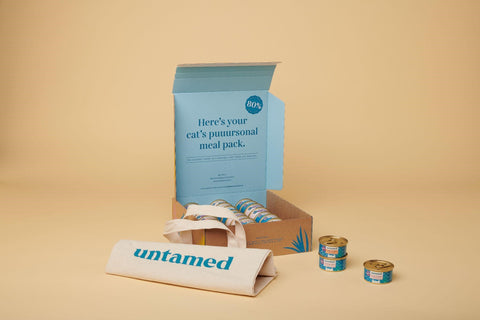 Untamed box featuring neatly packaged tins of cat food and an Untamed tote bag