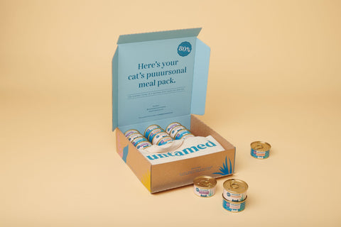 A brown and teal carton of various Untamed wet food cans forming a part of the trial pack