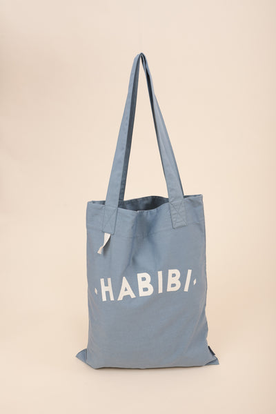  Tote Bag en toile, avec poche et anses intérieures, couleur bleu clair by LYOUM. Broderie 'Habibi' ('Mon Amour' en arabe) sur un côté en fil écru.