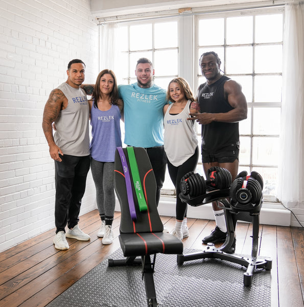 Group of Rezlek Fitness Athletes standing together behind some of the Rezlek Fitness products