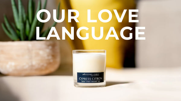 Cypress Citron candle by Fjord & Fable in focus, with text 'OUR LOVE LANGUAGE' above on graphic, and a blurred succulent and yellow backdrop.