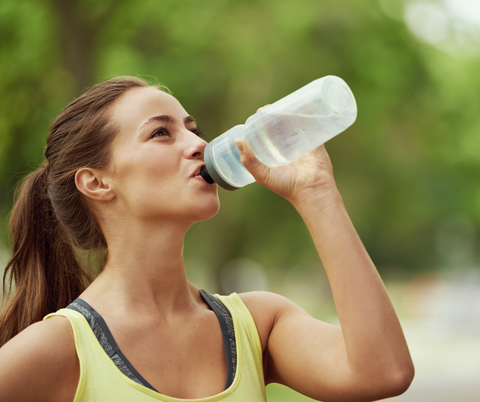 a woman drinking out of a water bottle