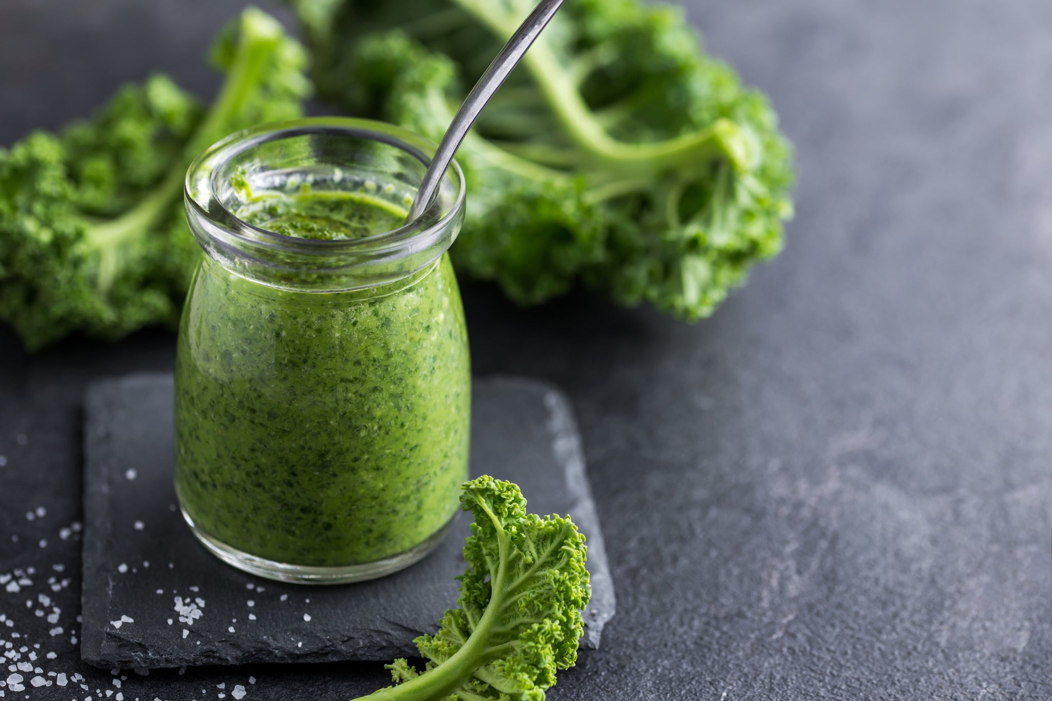 Green vegetable smoothie with kale in the background