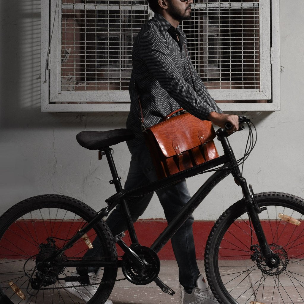 man cycling with leather bag