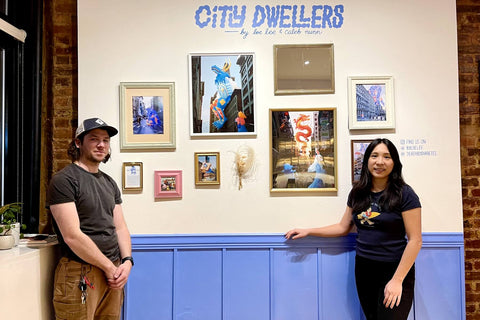 Loe & Caleb standing in front of their exhibition at Artbean Coffee