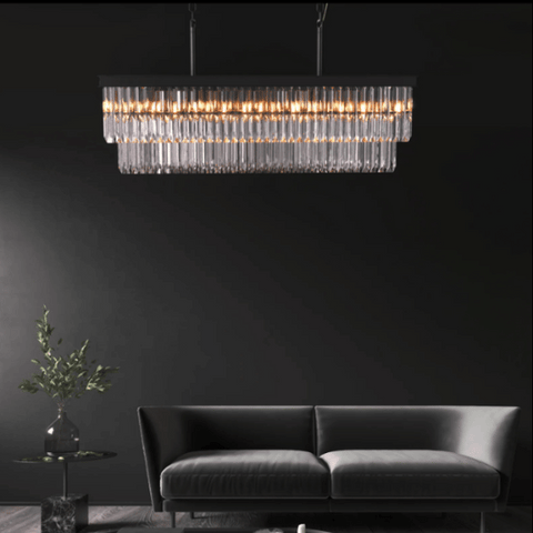 Rectangular crystal chandelier placed in a dark living room with dark walls.