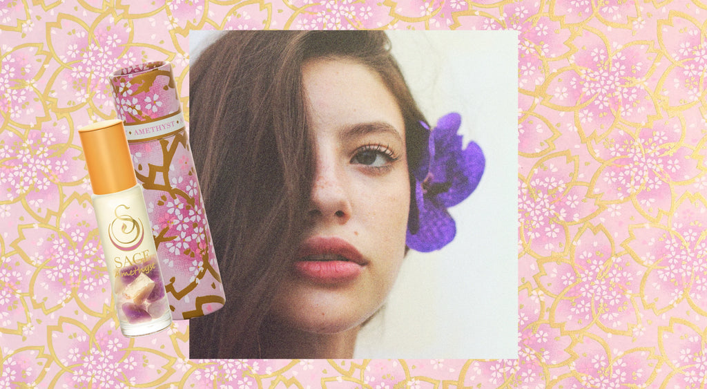 image of amethyst glass bottle with crystals infront of women’s face with purple flower in her hair