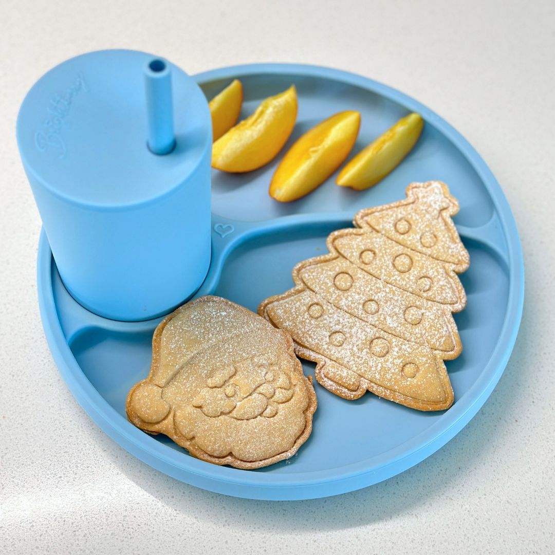 smoothie, fruit and christmas cookies served on a brightberry divided plate and silicone straw cup