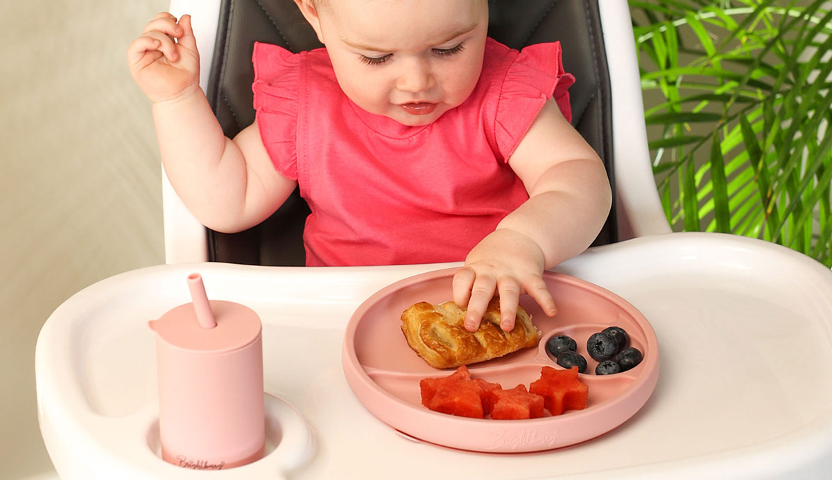 bébé tout-petit prenant son petit-déjeuner avec la plaque d'aspiration Brightberry