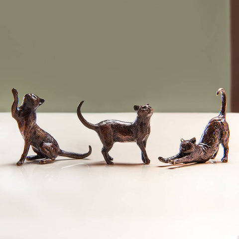 set of three bronze cat sculptures - one sitting, one, stretching and one standing