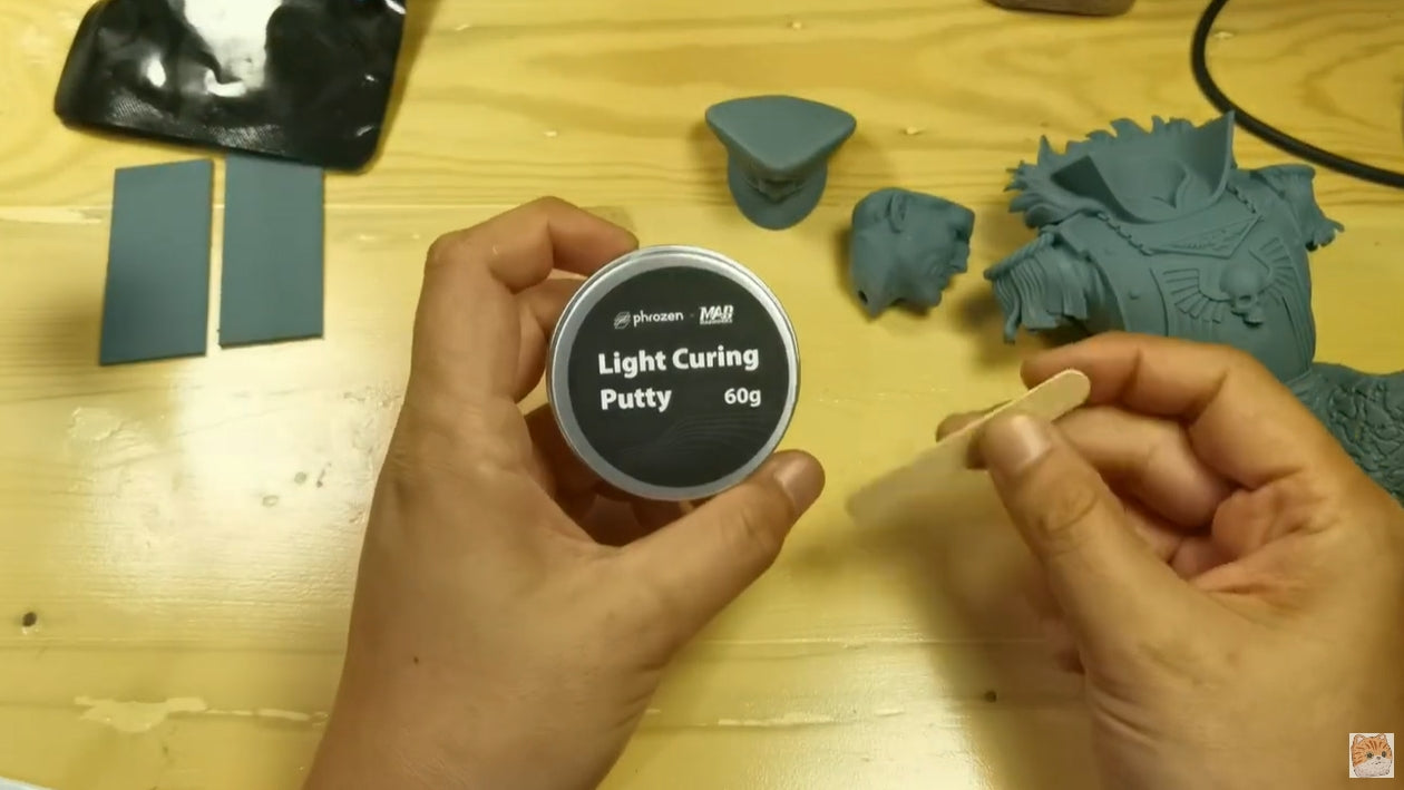 Inside the plastic packaging of the Light Curing Putty is a can of putty and a wooden stick