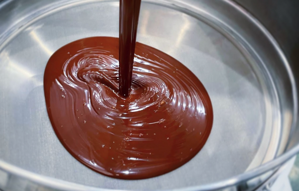 chocolate being poured into a sieve with a fine mesh
